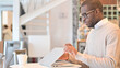 © stockbakers - Professional African Man Opening Laptop for Work