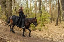 Beautiful Woman Riding In Historical Costume As A Warrior Comes Down The Hill