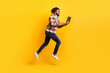 © deagreez - Full length body size photo of man jumping high working on laptop for start-up isolated on vibrant yellow color background