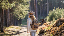Woman With Hat And Backpack Hiking In Woodland.  Adventure In Nature. Female Tourist Walking In Forest Alone