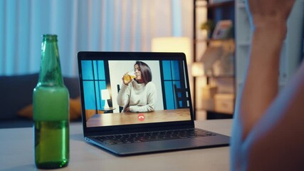 Wall Mural - Young Asia female drinking beer having fun happy moment night party event online celebration via video call in living room at house at night. Social distancing, quarantine for coronavirus prevention.