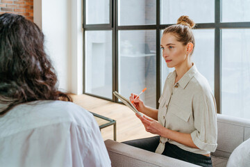 Wall Mural - Female coach interviewing her trainee indoor