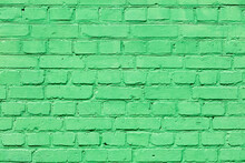A Very Old Brick Wall Completely Painted With Green Paint.