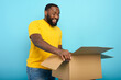 © alphaspirit - Happy man receives a package from online shop order. happy expression. Blue background.