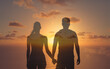 © kieferpix - Man and woman holding hands facing the sunset.