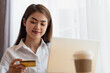 © surachetkhamsuk - Asian woman holding credit card and using laptop for online shopping