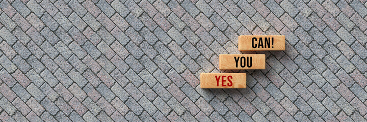 Wall Mural - cubes with message YES YOU CAN on stone pavement background