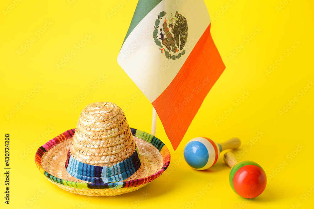 Mexican flag, maracas and sombrero hat on color background