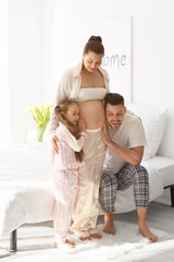 Wall Mural - Young pregnant woman with her family at home