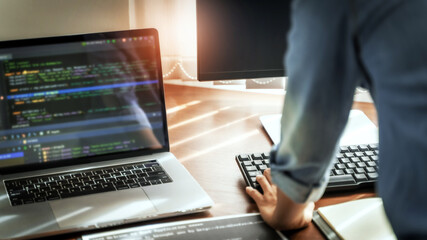 Wall Mural - programming developing software application. programmer writing program code with two monitors and w