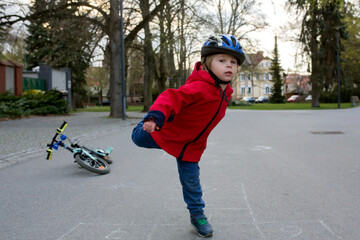 Wall Mural - Cute child, toddler boy, playing hopscotch, running and riding bike in the park