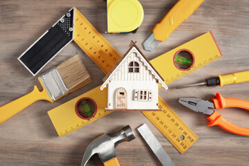 Wall Mural - Work tools with a wooden house model.