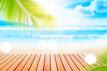 Wall Mural - blur tropical beach with bokeh sun light wave and palm tree on empty old wood table abstract backgro
