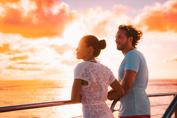 Wall Mural - Sunset cruise romantic couple watching view from boat deck on travel vacation. Silhouette of man and woman tourists relaxing on outdoor balcony of ship.