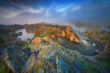 Wall Mural - drammatic landscape on the river with rocks and fog