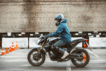 motorcycle driving school. a woman learns to drive before obtaining a driving license. 