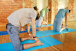 © Syda Productions - fitness, sport and healthy lifestyle concept - group of people doing yoga camel pose on mats in gym or studio