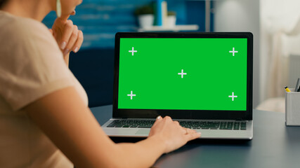 Close up of freelencer typing on isolated laptop for business commerce. Caucasian woman working on computer with mock up green screen chroma key display in home office studio.