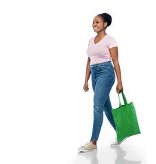 sustainability and people concept - happy smiling young african american woman with green reusable canvas bag for food shopping walking over white background