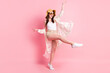Full body photo of carefree cheerful lady open mouth raise foot rejoice isolated on pink color background