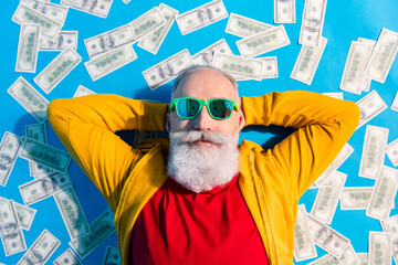 high angle view photo of happy good mood positive grandfather in sunglass lying floor with money iso