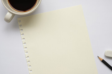 Wall Mural - cream colored paper, white coffee mug, black pencil and white eraser on white background, top view, 