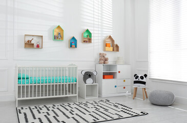 Poster - Comfortable crib near wall with color shelves in baby room. Interior design