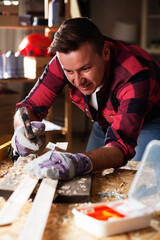 Wall Mural - Carpenter working on wood craft at workshop. Young man working in workshop.