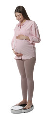 Canvas Print - Pregnant woman standing on scales against white background