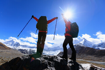 Wall Mural - Two women hikers hiking in winter high altitude mountains