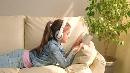 Wall Mural - The child in the headphones with the tablet. T