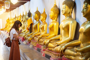 happy asian woman praying with buddha in temple
