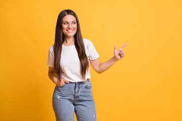 Sticker - Photo of pretty nice brown haired woman point finger empty space advertise isolated on shine yellow color background