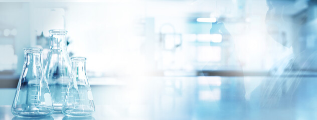 flask and shadow of scientist with protection glasses gloves in medical science lab blue banner back
