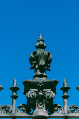 Poster - Closeup shot of a detail of the wrought iron gate against a blue sky in Alcala de Henares, Spain