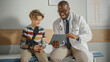 © Gorodenkoff - Friendly African American Family Doctor Talking with a Young Boy with Arm Brace and Showing Test Results on Tablet. Happy Medical Care Physician in a Hospital is Reassuring the Boy with Broken Arm.
