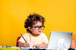 © shara - Portrait of smart school kid boy at home making homework with tablet computer. Little child in glasses with pencil writing or drawing. Elementary school and education for kindergarten kids