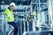 © Quality Stock Arts - Factory worker engineer working in factory using tablet computer to check maintenance boiler water pipe in factory.
