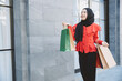 © Quality Stock Arts - Shopping Arab Muslim adult woman in veil hijab clothes holding bags walk in city street enjoy happy smile.