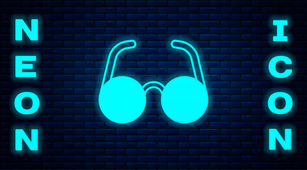 Sticker - Glowing neon Glasses icon isolated on brick wall background. Eyeglass frame symbol. Vector