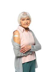 Wall Mural - Elderly woman with adhesive patch on arm looking at camera isolated on white