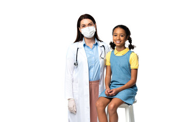 Wall Mural - Doctor in medical mask standing near smiling african american kid isolated on white