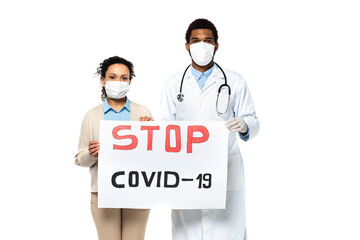 Wall Mural - African american doctor and patient holding placard with stop covid-2019 lettering isolated on white