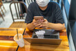 © Quang - Close up photo of woman wearing medical mask while sitting at coffeeshop