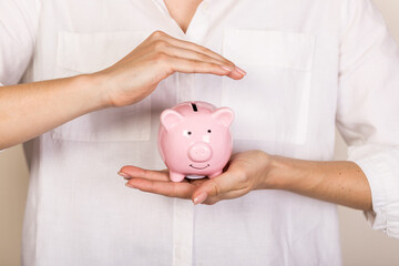 Wall Mural - Piggy bank in hand on light  background, space for text. Finance, saving money. Business to success and saving for retirement concept