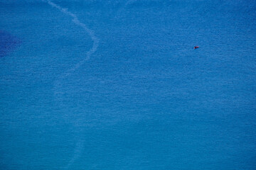 A canoe on the clean blue water of Trebarwith Strand.