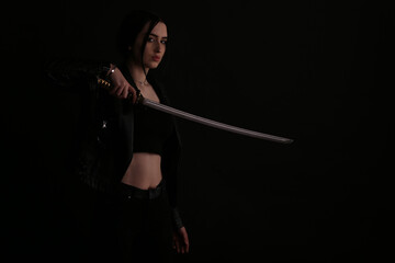 Woman with a katana sword on black background