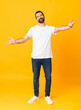 © luismolinero - Full-length shot of man with beard over isolated yellow background presenting and inviting to come with hand