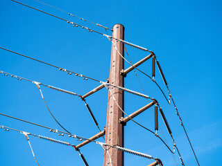 Industrial power pole and power lines against blue sky