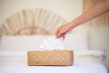 Woman hands pulling white tissue paper from wooden box,Protect your hands with a tissue